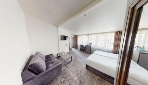 a hotel room with a bed and a couch at Median Hotel, City Center Yerevan in Yerevan