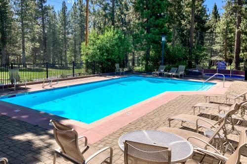 a large swimming pool with chairs and a table at Mammoth Green 101 in Mammoth Lakes