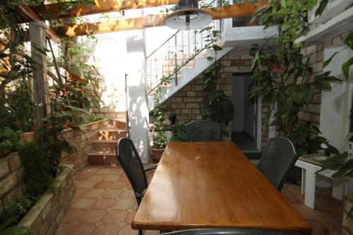 een houten tafel en stoelen in een kamer met planten bij Apartments by the sea Zaklopatica, Lastovo - 8357 in Lastovo