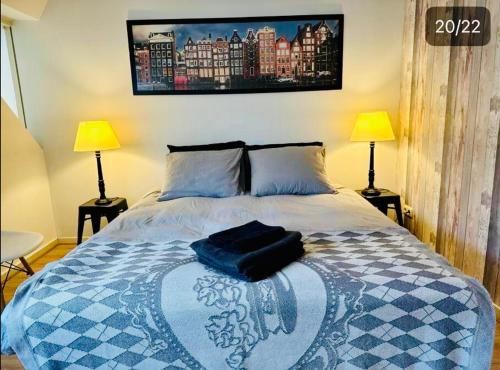 a bedroom with a bed with two lamps on it at Lovely Apartment Wassenaar 6P in Wassenaar