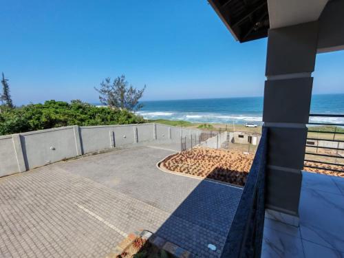 a view of the ocean from the balcony of a house at Modern Beachfront Escape in La Mercy in La Mercy