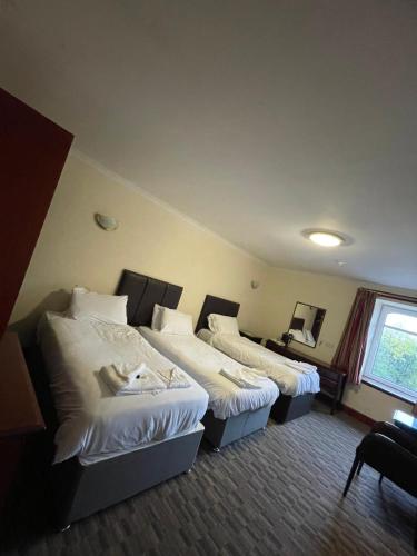a hotel room with two beds and a window at Lochway Hotel in Dumbarton