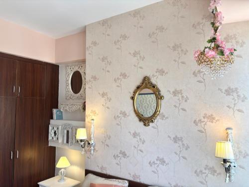 诺伊达Paris Style Luxe Apartment In The Heart Of Noida的带镜子的浴室和带鲜花的墙壁