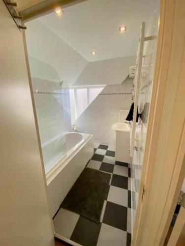 a bathroom with a black and white checkered floor at Lovely Apartment Wassenaar 6P in Wassenaar