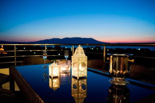 キサモスにあるVilla Levantes Ferienhaus In Mithimna Mit Poolのバルコニーの上にグラスとキャンドルが置かれたテーブル