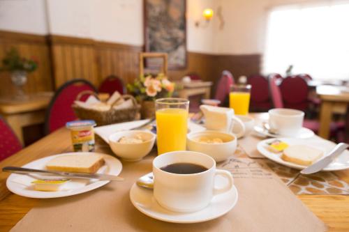 een tafel met borden eten en een kopje koffie bij Hostal Hielo Sur in Punta Arenas