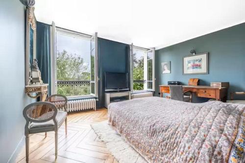 een slaapkamer met een bed, een bureau en ramen bij House, garden, Eiffel Tower, Palace of Versailles in Sèvres
