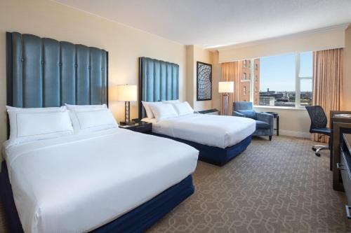 una camera d'albergo con due letti e una scrivania di The Marc Hotel a Milwaukee
