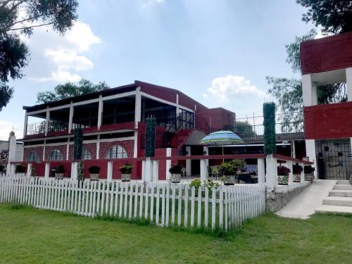 a building with a white fence in front of it at Rancho el Andariego and La Catrina 