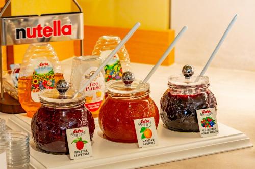 a table with three jars of jam on a tray at Hotel Birkenhof in Hanau am Main