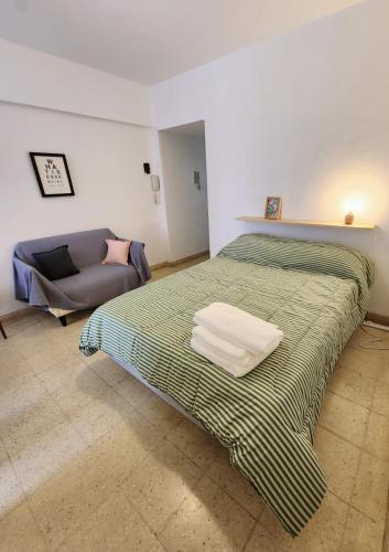 ein Schlafzimmer mit einem Bett und einer Couch in der Unterkunft Monoambiente y sala de estar con garage in Mar del Plata