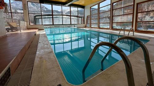 ein großes Schwimmbecken mit blauem Wasser in einem Gebäude in der Unterkunft Evenia Monte Alba in Aramón Cerler