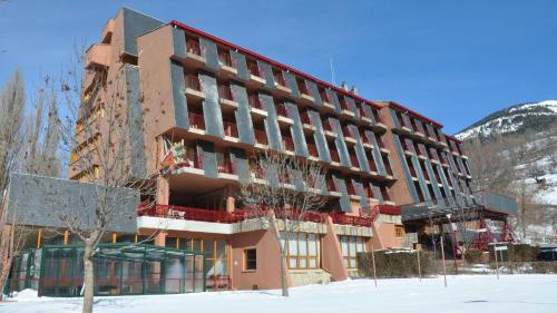 um grande edifício com neve em frente em Evenia Monte Alba em Cerler