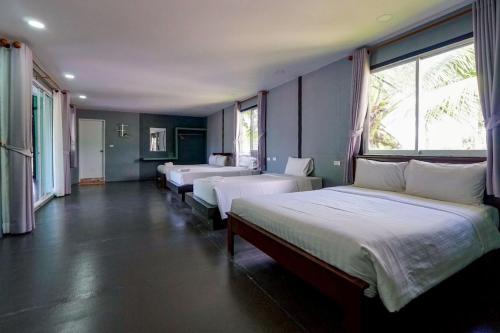 een kamer met 3 bedden en een groot raam bij 7Sea Beach Pool Villa in Ao Nam Mao