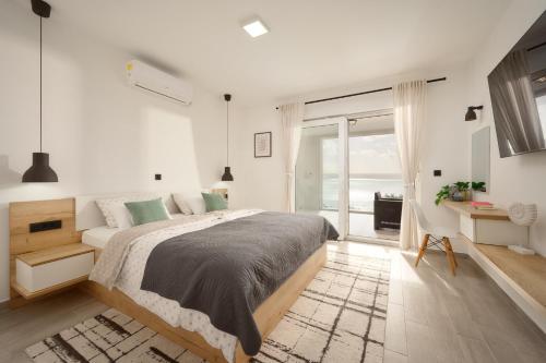 ein Schlafzimmer mit einem großen Bett und einem großen Fenster in der Unterkunft Stunning seaview Villa Katharina in Šarić