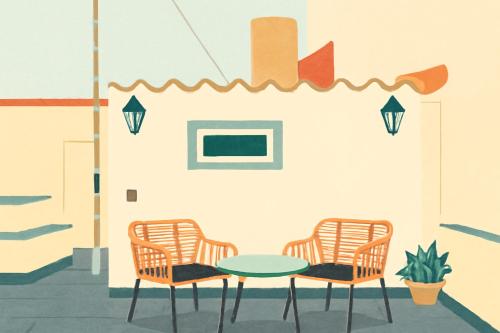 two chairs and a table in front of a wall at Domus Mare in Peñíscola