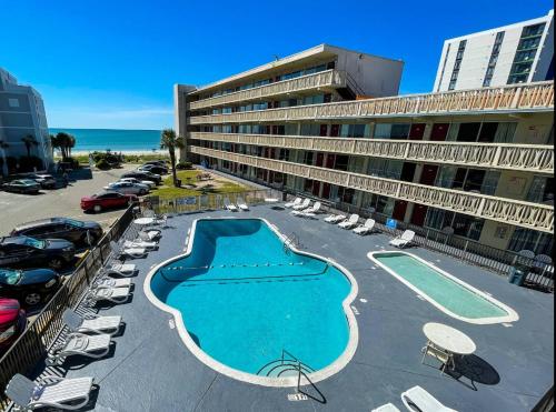a large hotel with a swimming pool and a parking lot at Viking Motel in Myrtle Beach