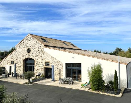 a large stone building with tables and chairs at "La Petite Félixière" à 25 min du Puy du Foù, 10 min de Cholet, et 35 min de Nantes in Saint-André-de-la-Marche