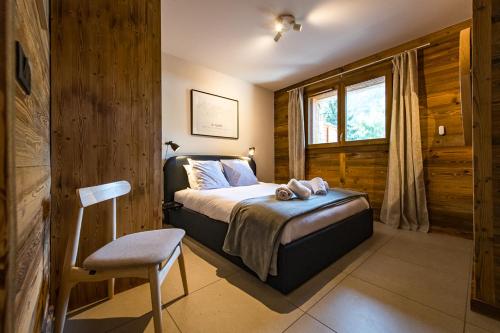 Appartement Haut de Gamme au cœur du village avec terrasse de 34m2 - 6 personnes في سانت سورلين دوارفيز: غرفة نوم بها سرير وكرسي ونافذة