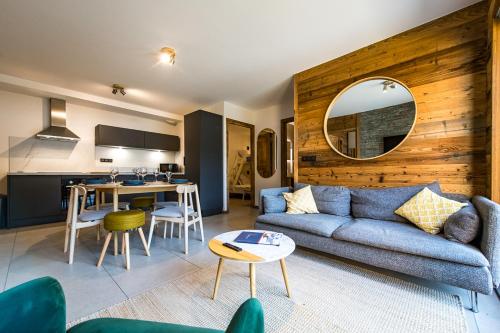 Appartement Haut de Gamme au cœur du village avec terrasse de 34m2 - 6 personnes في سانت سورلين دوارفيز: غرفة معيشة مع أريكة زرقاء ومطبخ