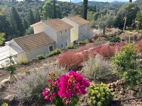a row of houses on a hill with flowers at Giardinia Holiday Homes with Private Pool in Gazátika