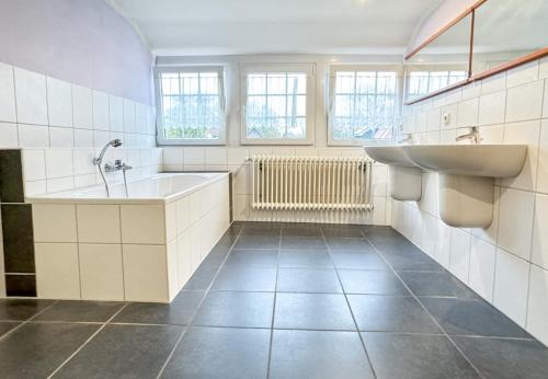 BunkenburgRuime accommodatie voor 10 personen in Marx的浴室配有盥洗盆、浴缸和盥洗盆