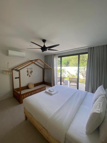 a bedroom with a large white bed and a window at Villa Amour 3 Bedroom Spa Pool Retreat near Beach - Lamai in Lamai