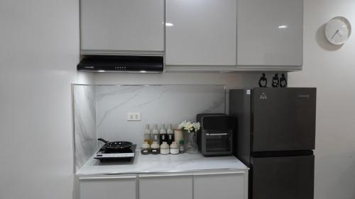 a small kitchen with a refrigerator and a microwave at 1BR with Pool at One Pontefino Tower, Batangas City in Batangas City