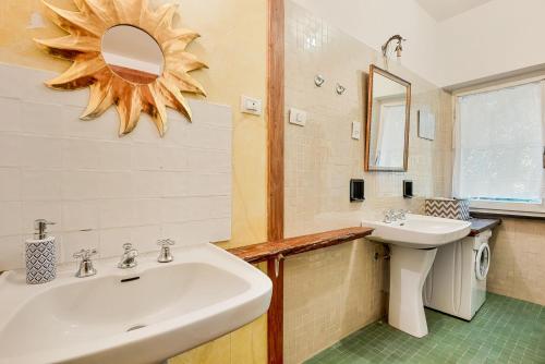 a bathroom with a sink and a mirror at La dimora dell'artista sea view free parking in San Terenzo