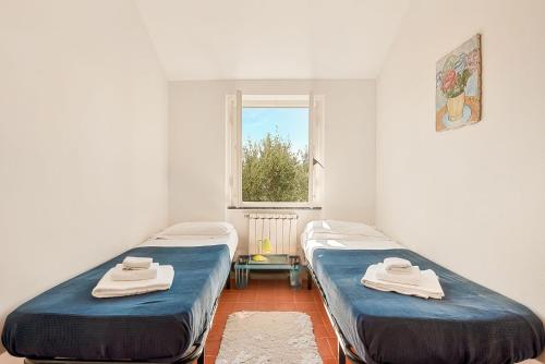 two beds in a room with a window at La dimora dell'artista sea view free parking in San Terenzo