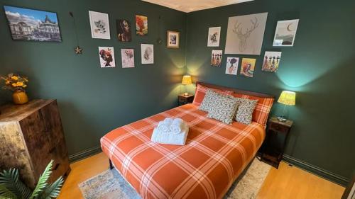 Schlafzimmer mit einem Bett und Bildern an der Wand in der Unterkunft Watford High Street apartment with kitchen & sofa bed in Watford