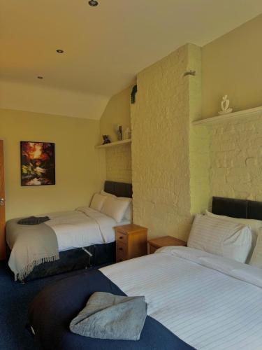 ein Zimmer mit drei Betten in einem Zimmer in der Unterkunft Mallview Coach House in Armagh