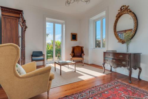 a living room with a table and chairs and a mirror at Casa da Cal - by Casas na Ilha in Câmara de Lobos