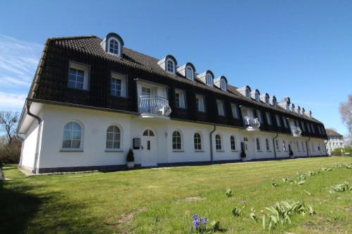a large white building with a black roof at Ostseeloft Wischuer in Rerik