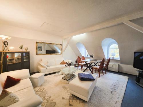 a living room with white furniture and a dining room at Ostseeloft Wischuer in Rerik