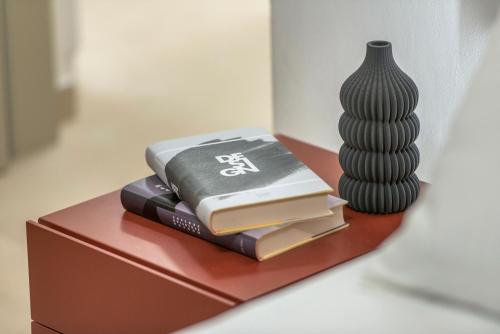 a stack of books on a table next to a vase at Palazzo Degli Eletti R&R in Venice
