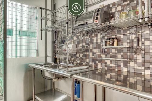 a kitchen with a sink and a tiled wall at Centric 2 BR Condo - Roma - Rio de Janeiro Park in Mexico City