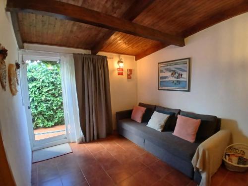 een woonkamer met een bank en een raam bij Casa Rustica - Courtyard House in Olhão