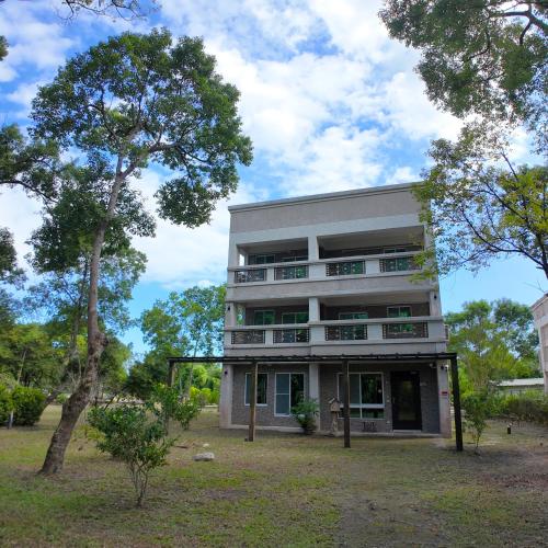 a building with a tree in front of it at Shu Hai Cui Hu Homestay in Zhixue