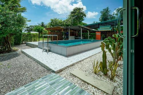 een zwembad in een tuin met een huis bij 7Sea Beach Pool Villa in Ao Nam Mao
