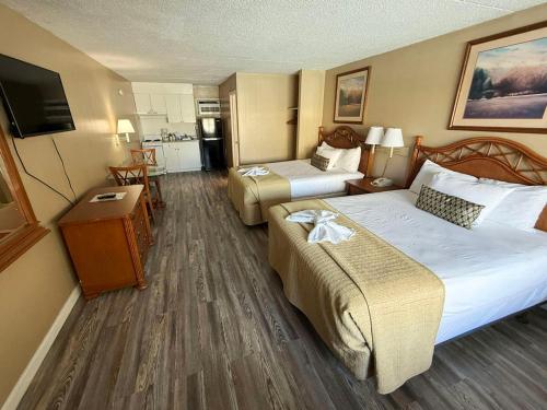 a hotel room with two beds and a flat screen tv at Viking Motel in Myrtle Beach