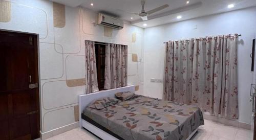 a bedroom with a bed and a window with curtains at RR Villa in Bantvāl