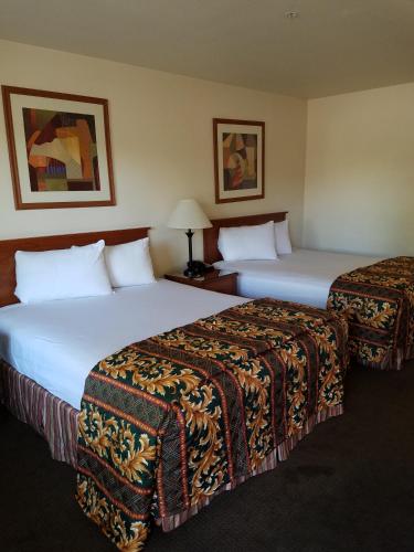 two beds in a hotel room with two at Premier Inns Tolleson in Phoenix