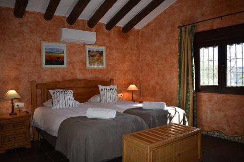 two beds in a room with orange walls at Finca Higueron with private Pool in Río