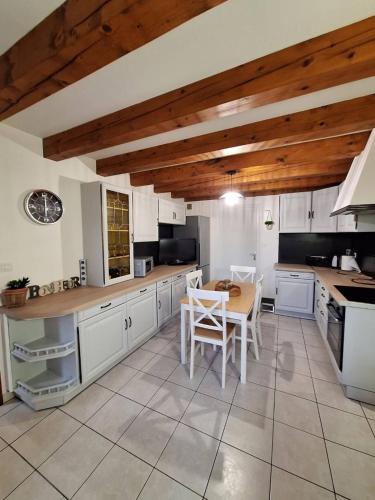 a kitchen with white cabinets and a table and chairs at La Fermette Aux Lamas in Savigny-Lévescault