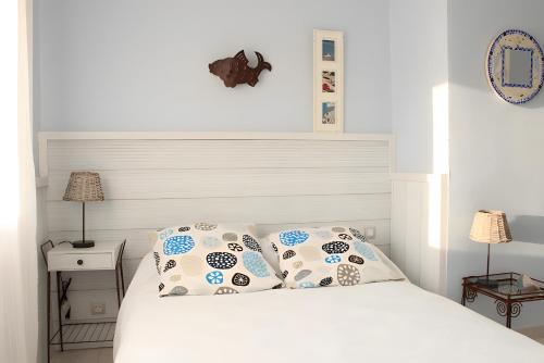 a bedroom with a white bed with two pillows at Chambre d'hôtes - Le quartier haut in Sète
