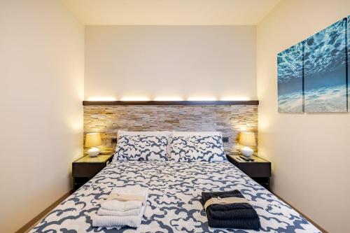 a bedroom with a large bed with two night stands at Una spettacolare vista mare - Casa con Jacuzzi in Bergeggi