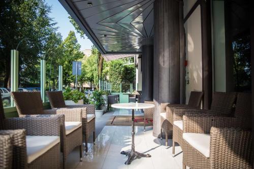 a patio with chairs and a table in a restaurant at Hotiday Conegliano in Conegliano