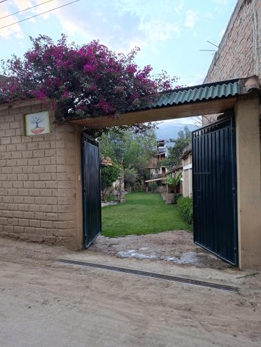an entrance to a building with a gate and flowers at Qushi Shoncu Lodge in Huaylas
