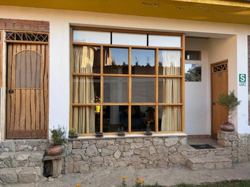a house with a window and a door at Qushi Shoncu Lodge in Huaylas